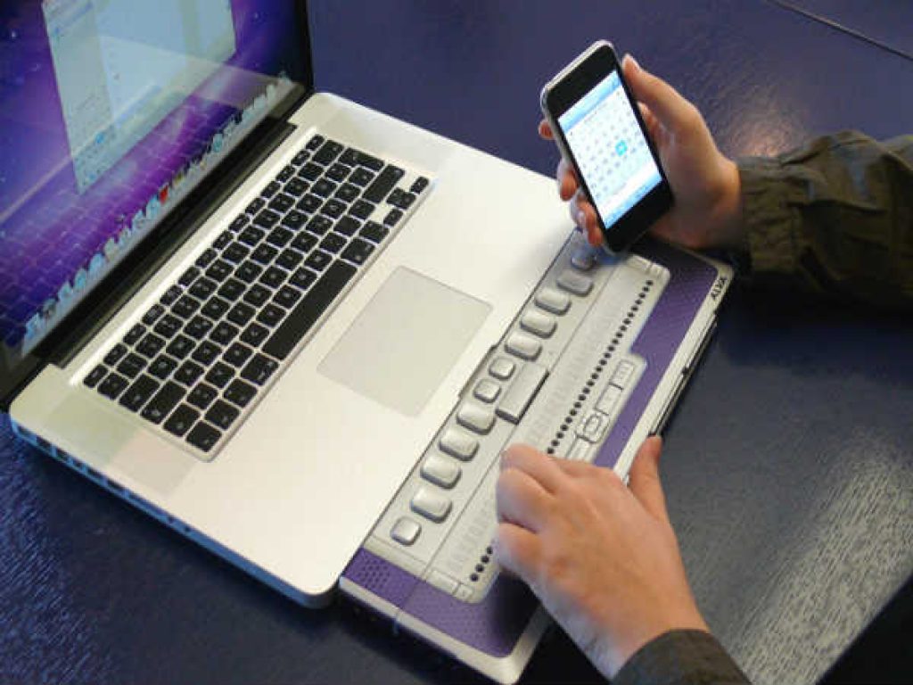 A visually impaired person using the braille display to access the web